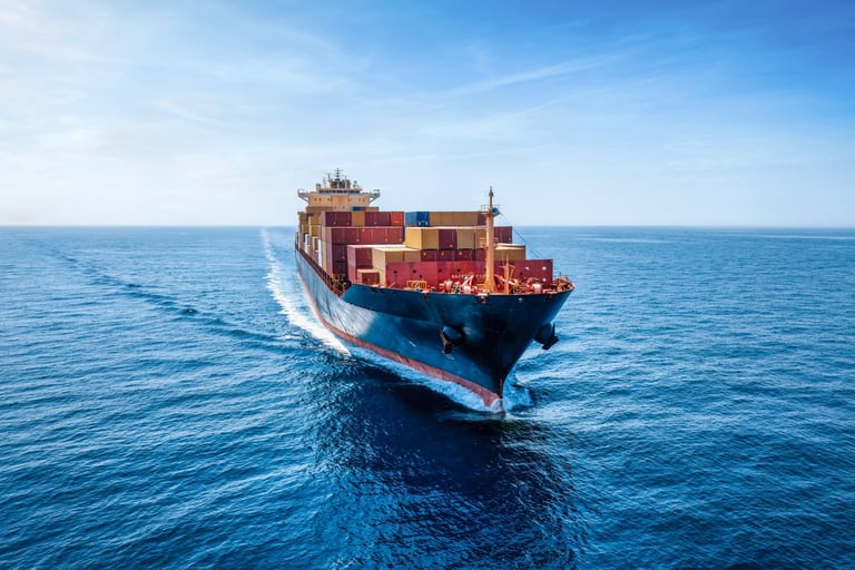 Aerial front view of an industrial container cargo ship traveling over the calm ocean