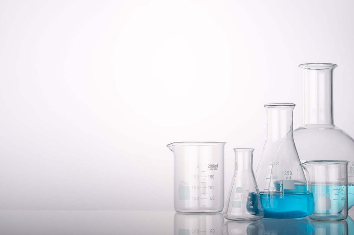 Science and medical background with laboratory glass chemical containers on glass table